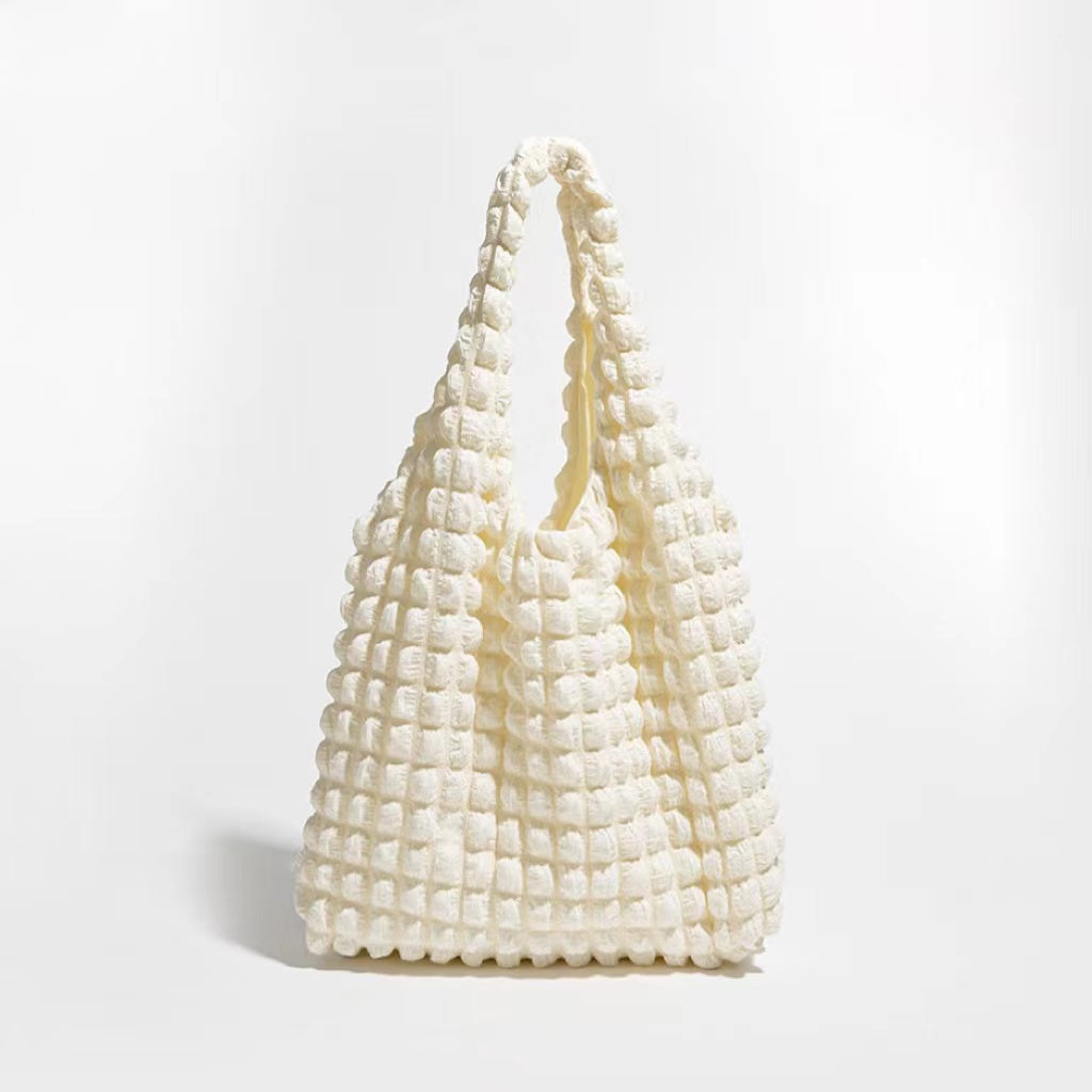 Front view of the cream-colored bubble textured tote bag.