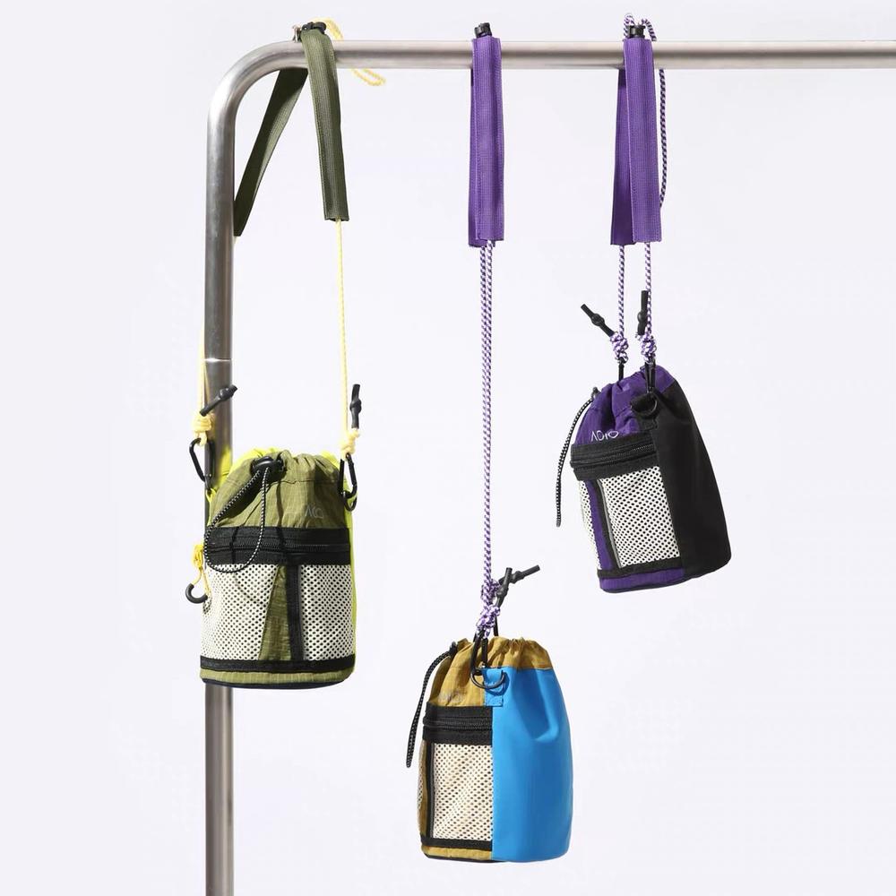 3 colors of mini bucket bags hanging on rack. Adjustable straps. Versatile outdoor style.