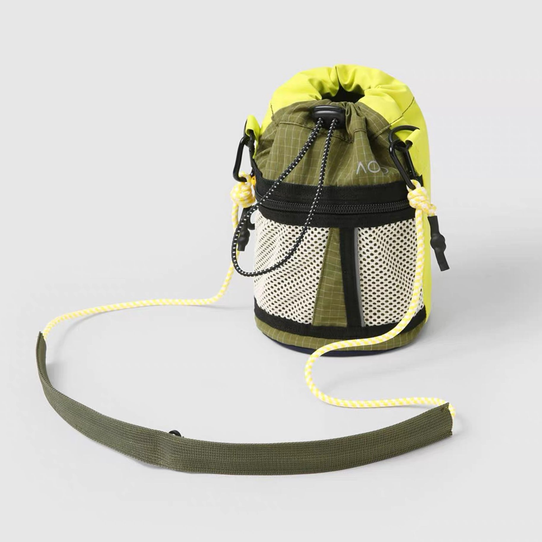 Front view of olive green and lime green nylon bucket bag with mesh front pocket and drawstring closure.