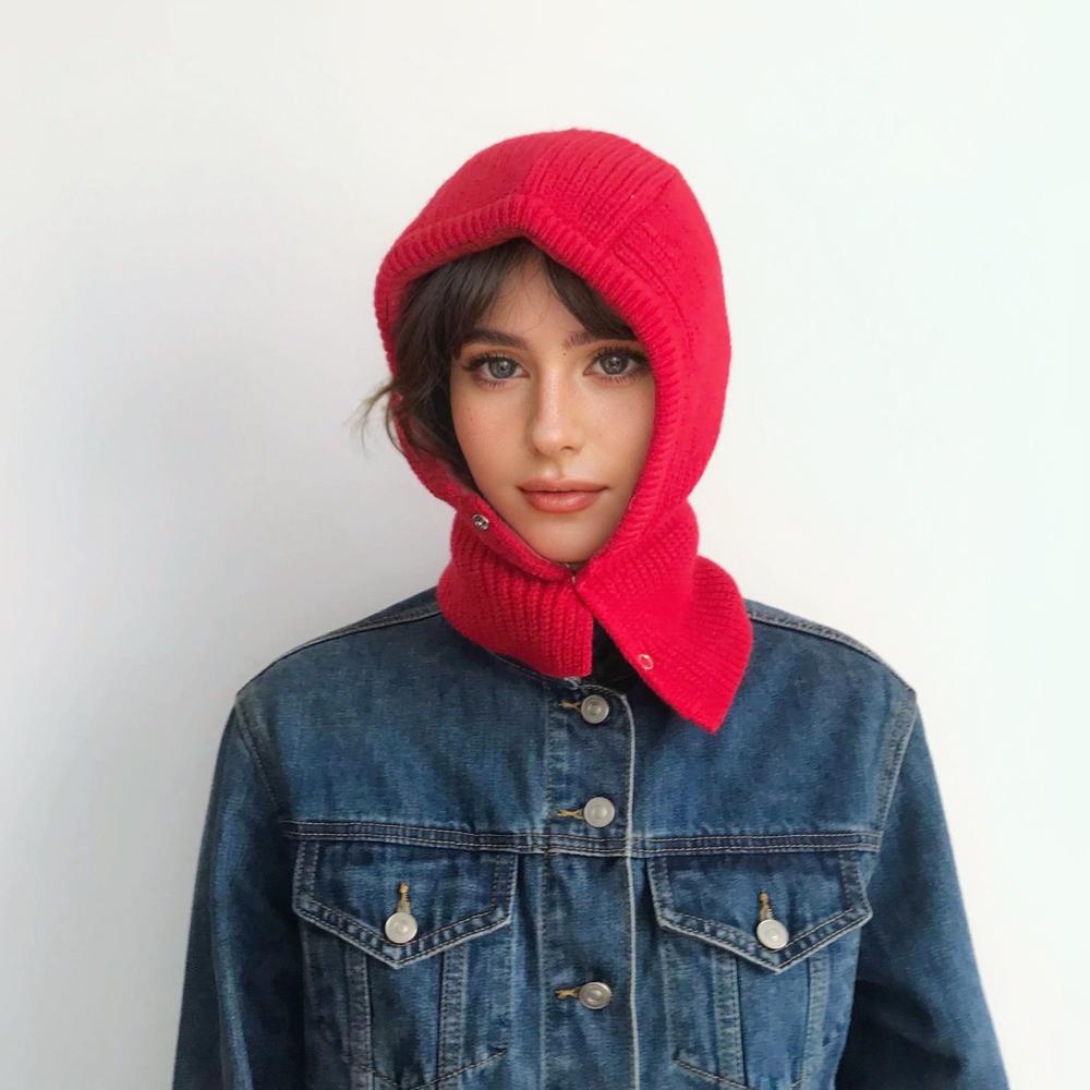 Model wearing vibrant multi-tone pattern balaclava hat, showcasing a unique and artistic knitted design.