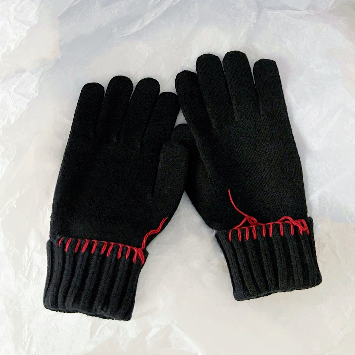 Black colored-thread hemming gloves with contrast stitching; classic knit warmth for cold weather.