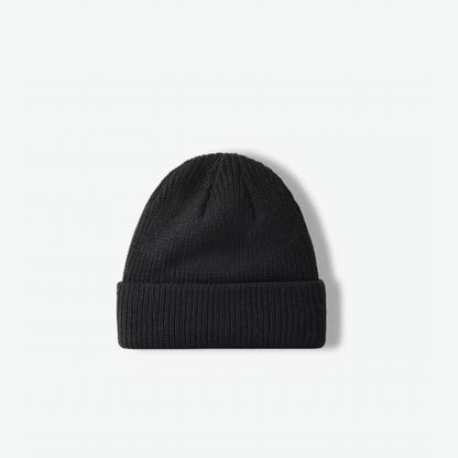 Front view of a timeless black rib-knit acrylic beanie skullcap.