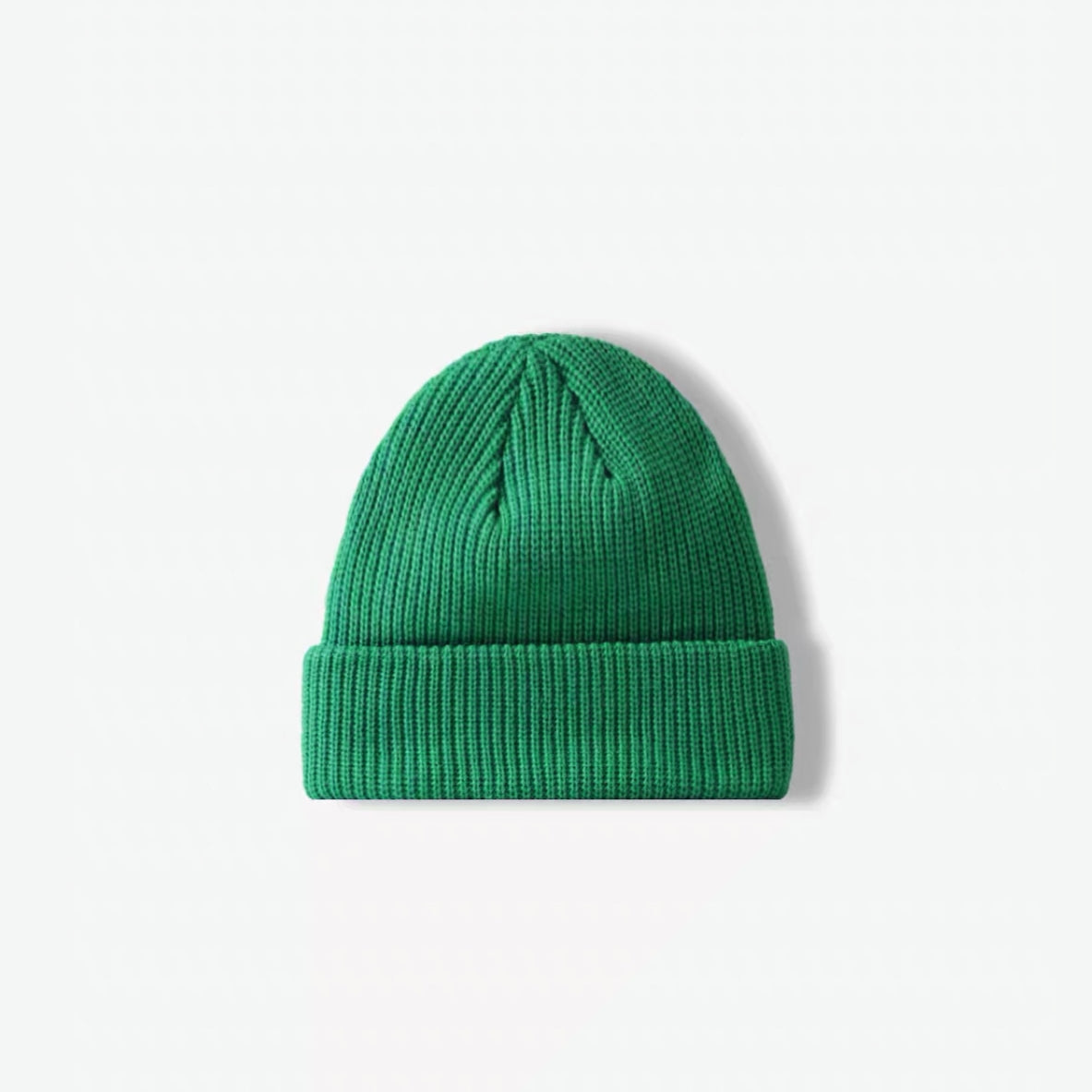 Front view of a grass green turned-cuff acrylic knitted beanie.