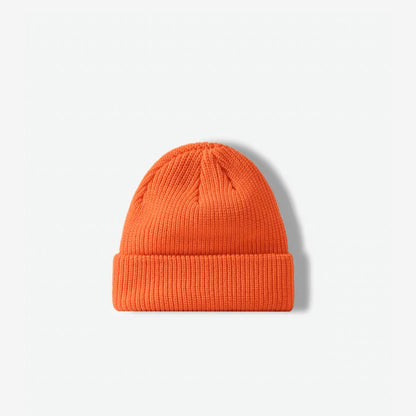 Front view of a bright orange knitted beanie featuring a folded cuff texture.