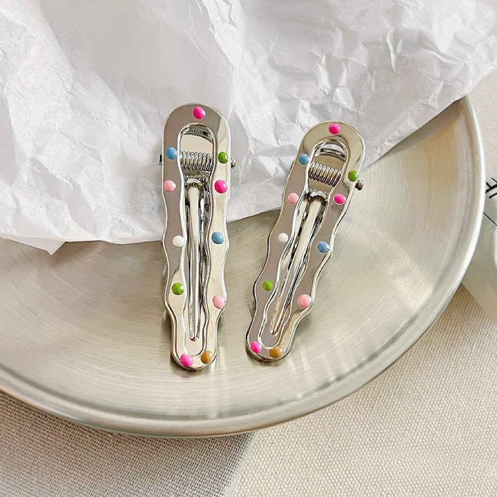 Angled view of Colorful Polka Dot Hair Clip in wave shape, ideal for quick updos and ponytails.