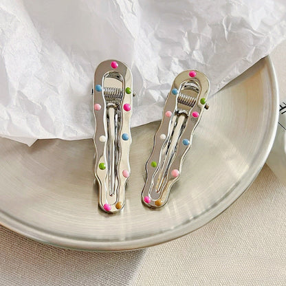 Angled view of Colorful Polka Dot Hair Clip in wave shape, ideal for quick updos and ponytails.