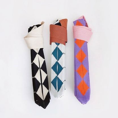 Demonstrating the foldable storage feature of the argyle knit bag, rolled into a compact size.