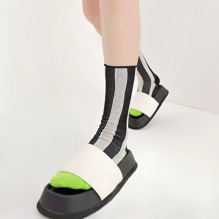 Model wearing a pair of Contrast Color Striped Socks in black, easy to pack for travel and errands.