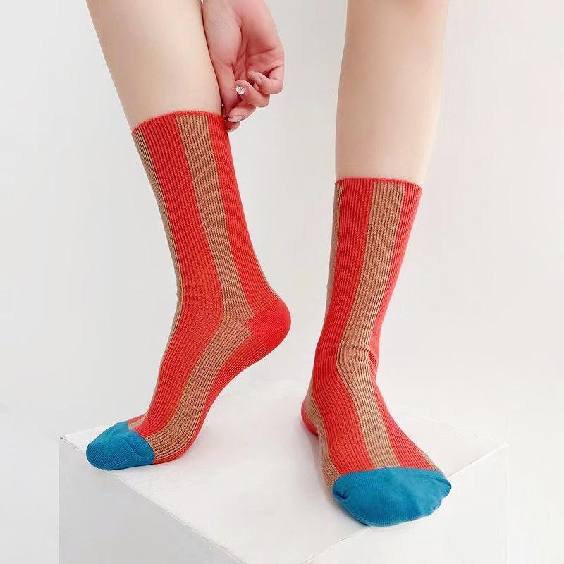 Model wearing a pair of red Contrast Color Striped Socks, great for casual wear and light workouts.