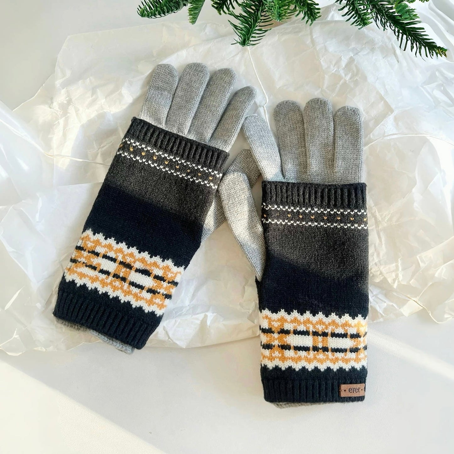 Convertible Fair Isle knit cuff gloves in navy/grey with tan pattern, layered over grey gloves; cozy winter wear.