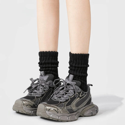 Model wearing a pair of  Cotton Slouch Socks in black, easy to pack for travel and errands.