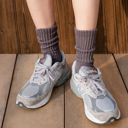 Model wearing a pair of Cotton Slouch Socks in gray, ideal for workouts and commuting.