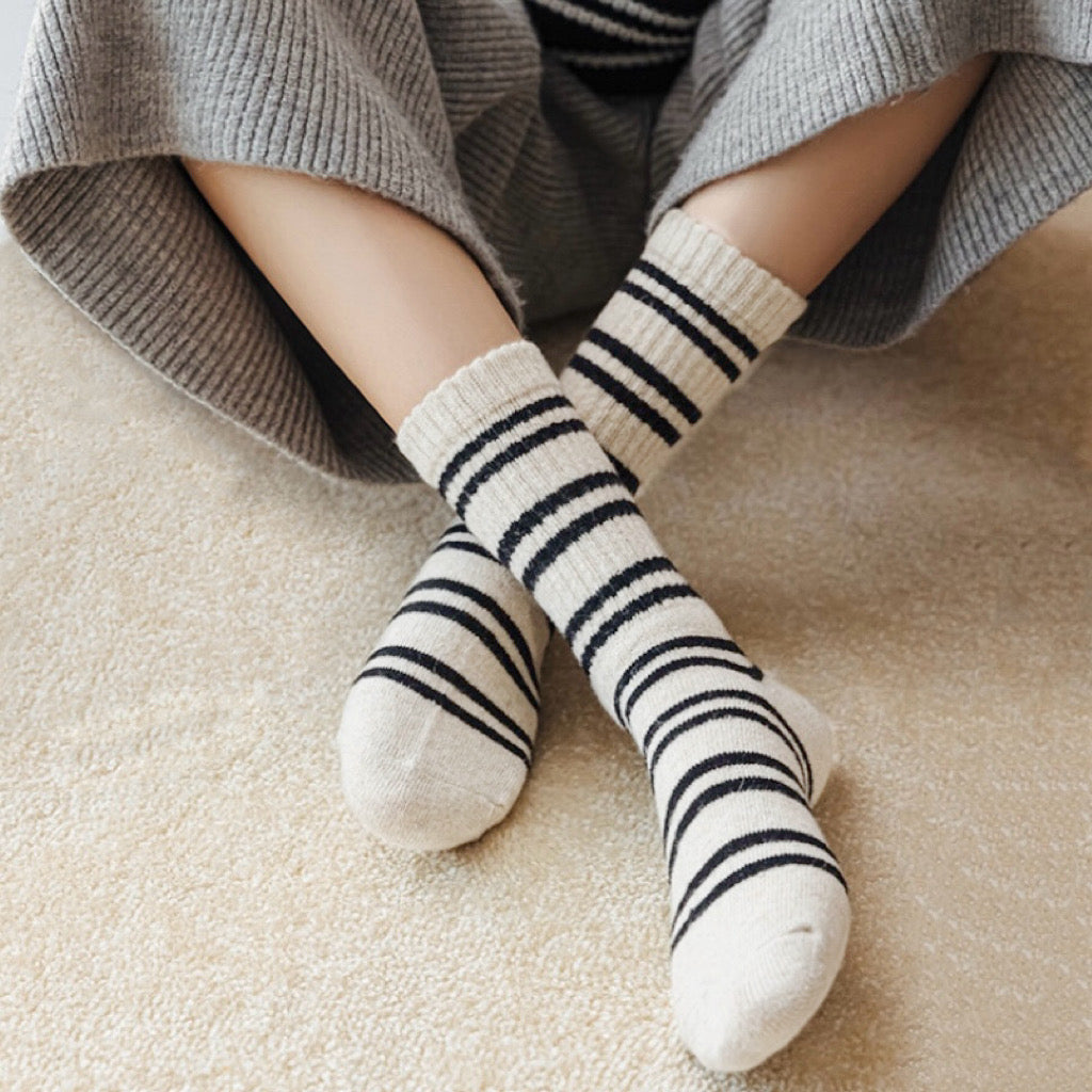 Model wearing a pair of beige striped wool socks, ideal for everyday outfits and sneakers.
