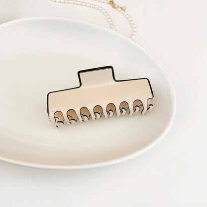 Angled view of Cream Black Border Hair Claw in rectangle shape, great for everyday styling and gifting.