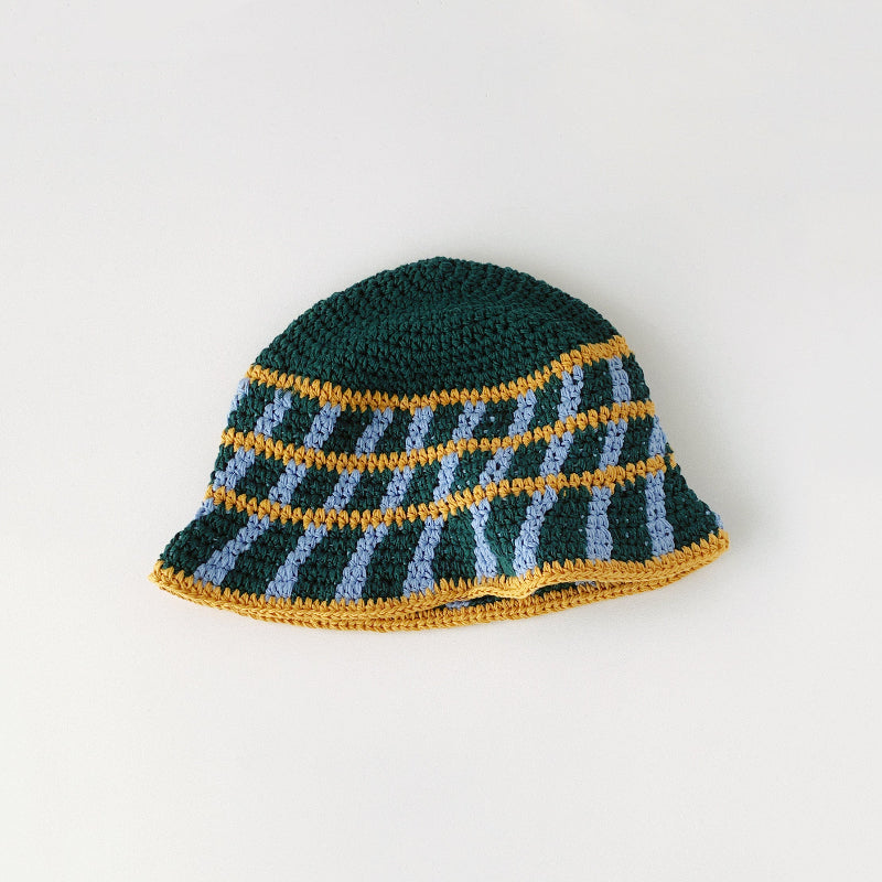 Detailed top view of the green bucket hat, with yellow and light blue cross striped pattern.