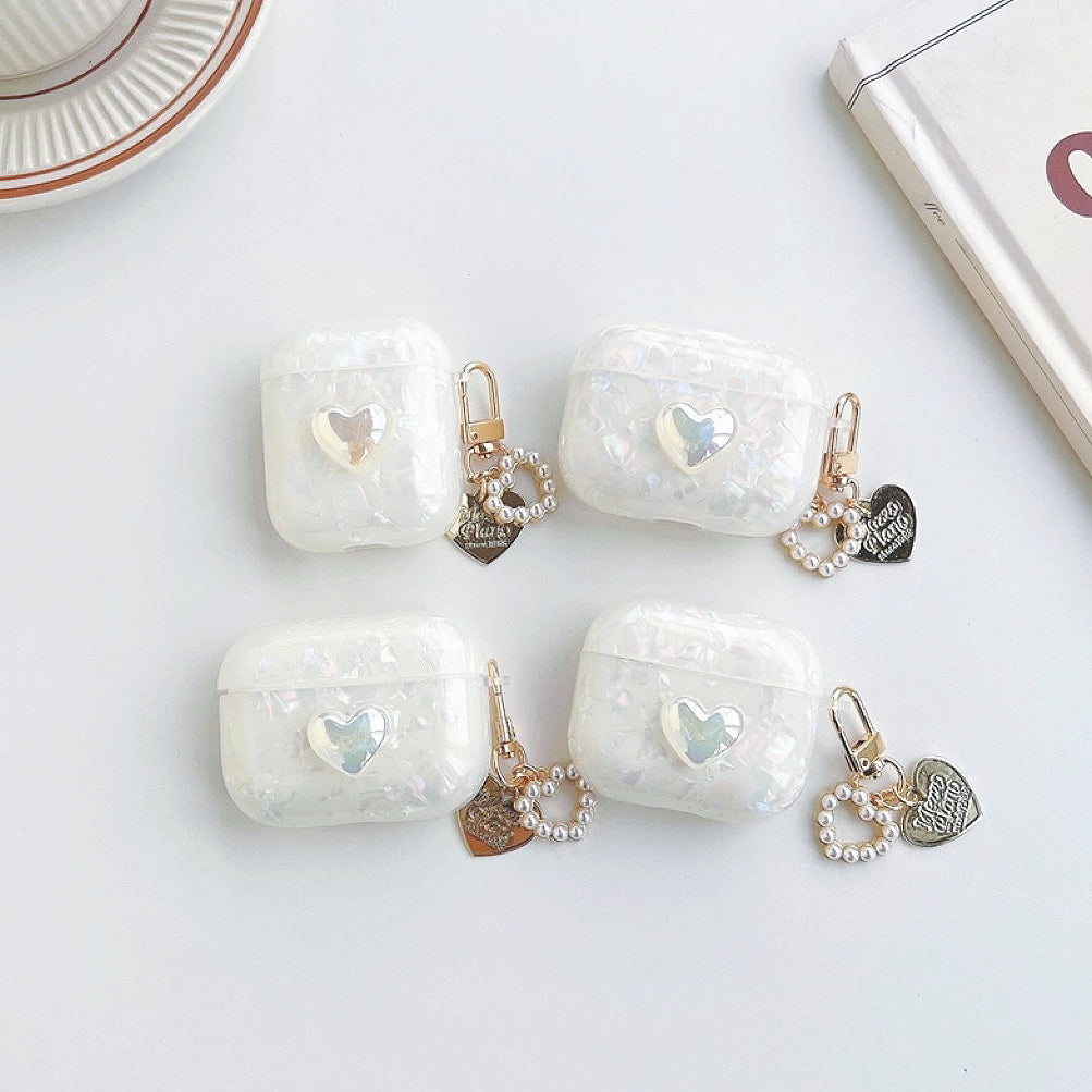 Four iridescent white silicone AirPods cases with a heart design and pearl chain charms.