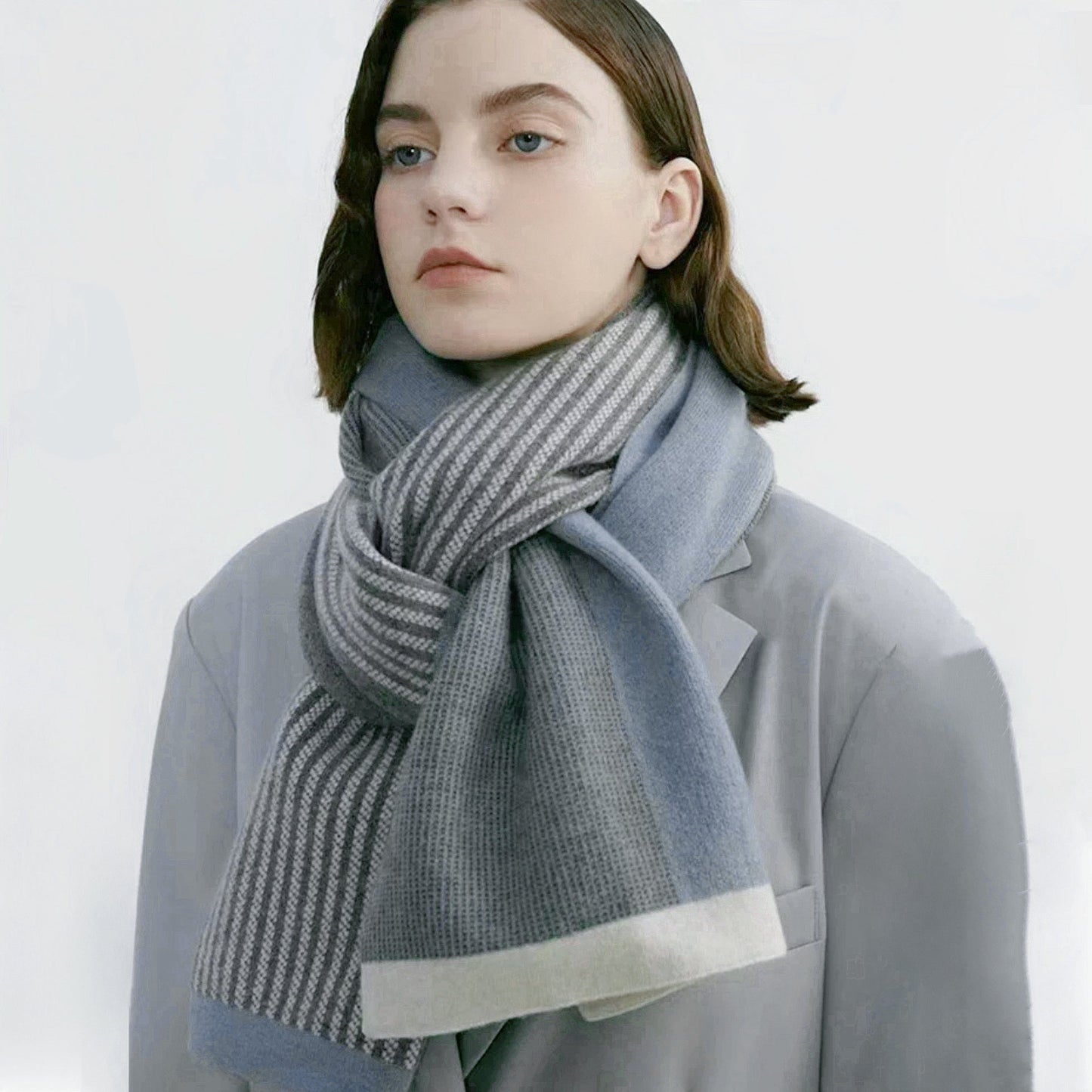 Model wearing a striped scarf in gray and blue, ideal for daily wear and travel.