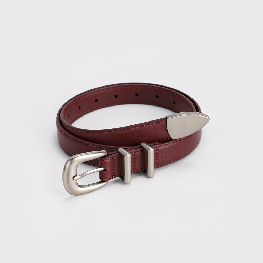 Burgundy leather belt with double keeper loops rolled up showing silver buckle detail.