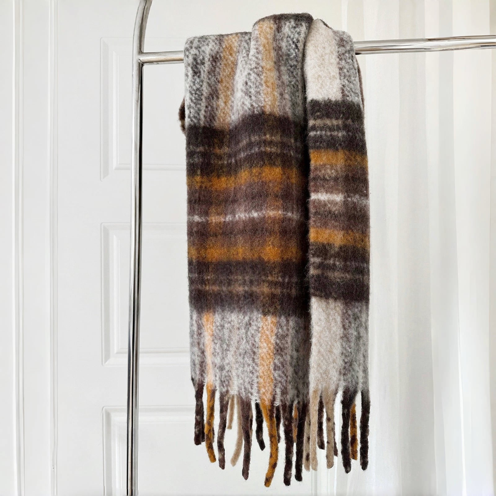 Flat lay of Fiery Sunrise Plaid Scarf in brown and yellow, easy for travel packing and gifting.