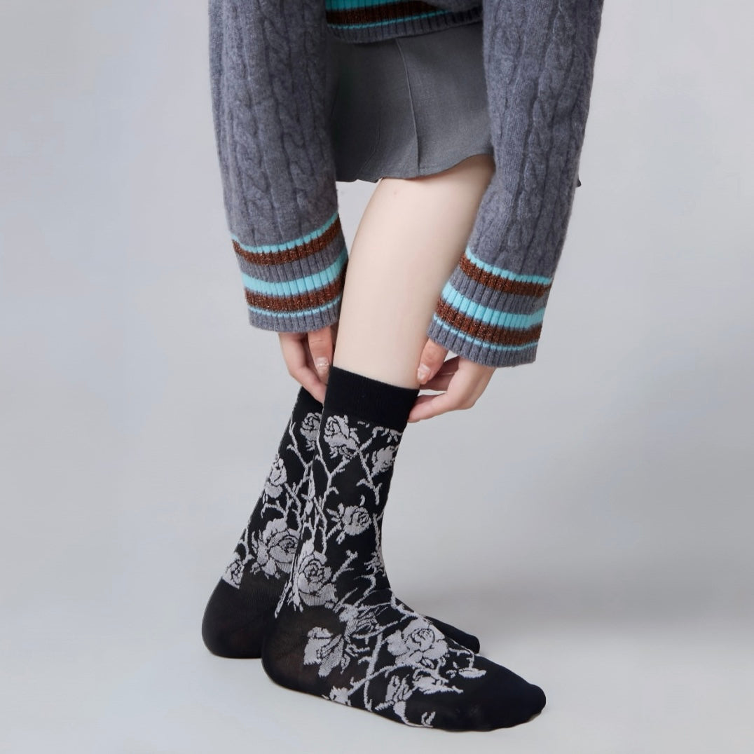 Model wearing a pair of black Floral Embroidered Socks, great for casual wear and light workouts.