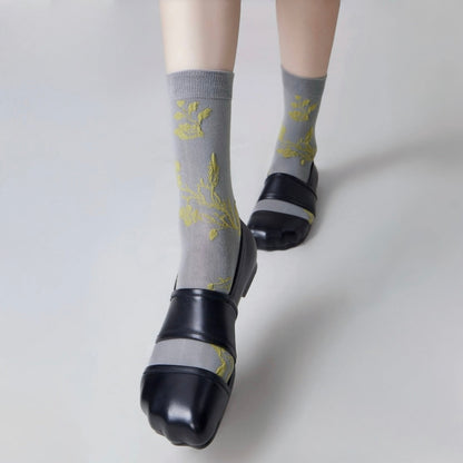Model wearing a pair of Floral Embroidered Socks in gray, easy to pack for travel and errands.