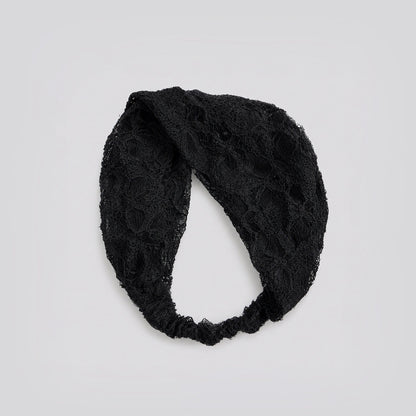 Studio view of the black floral lace headband looped to show its flexible stretch construction and floral pattern.