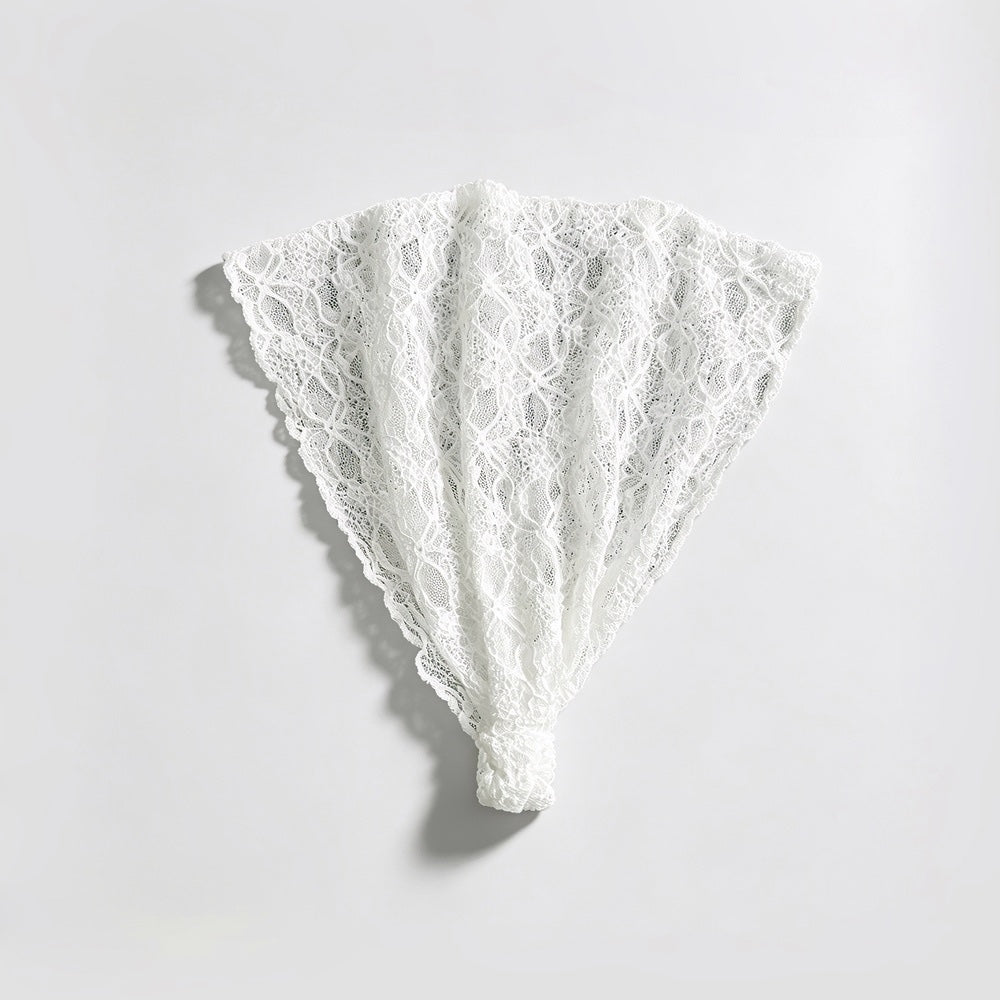 Studio flat lay of the white floral lace headband unfolded into a fan shape displaying the elastic bottom band.
