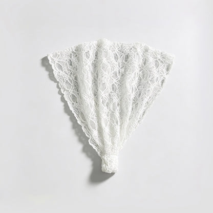 Studio flat lay of the white floral lace headband unfolded into a fan shape displaying the elastic bottom band.