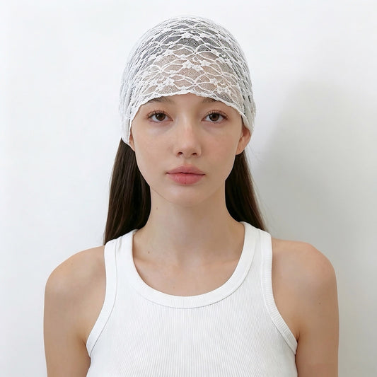 Front view of a model with long straight brown hair wearing the white floral lace headband spread wide across the crown.