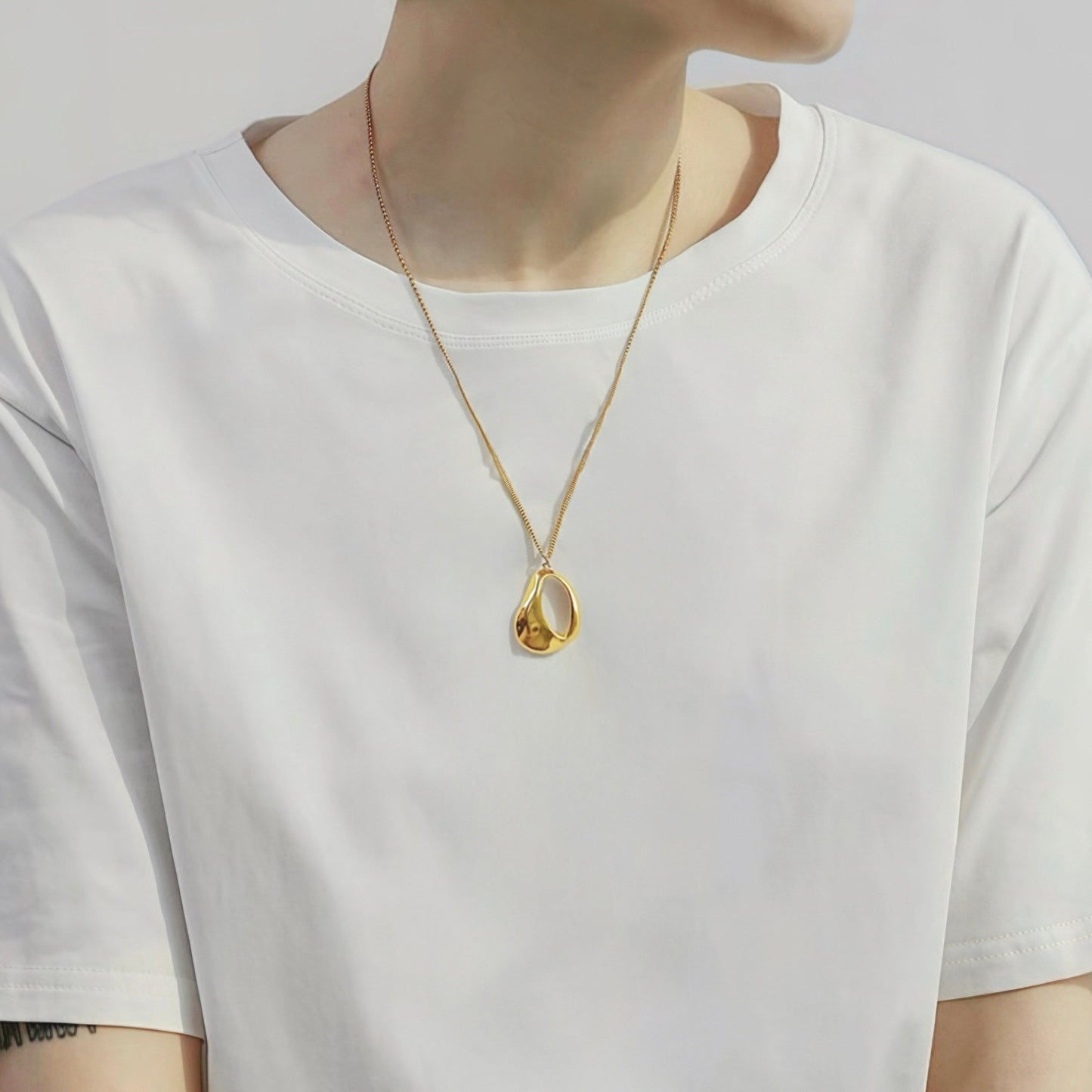 Model styling a Fluid Shapede Pendant Necklace in Gold, ideal for date nights.