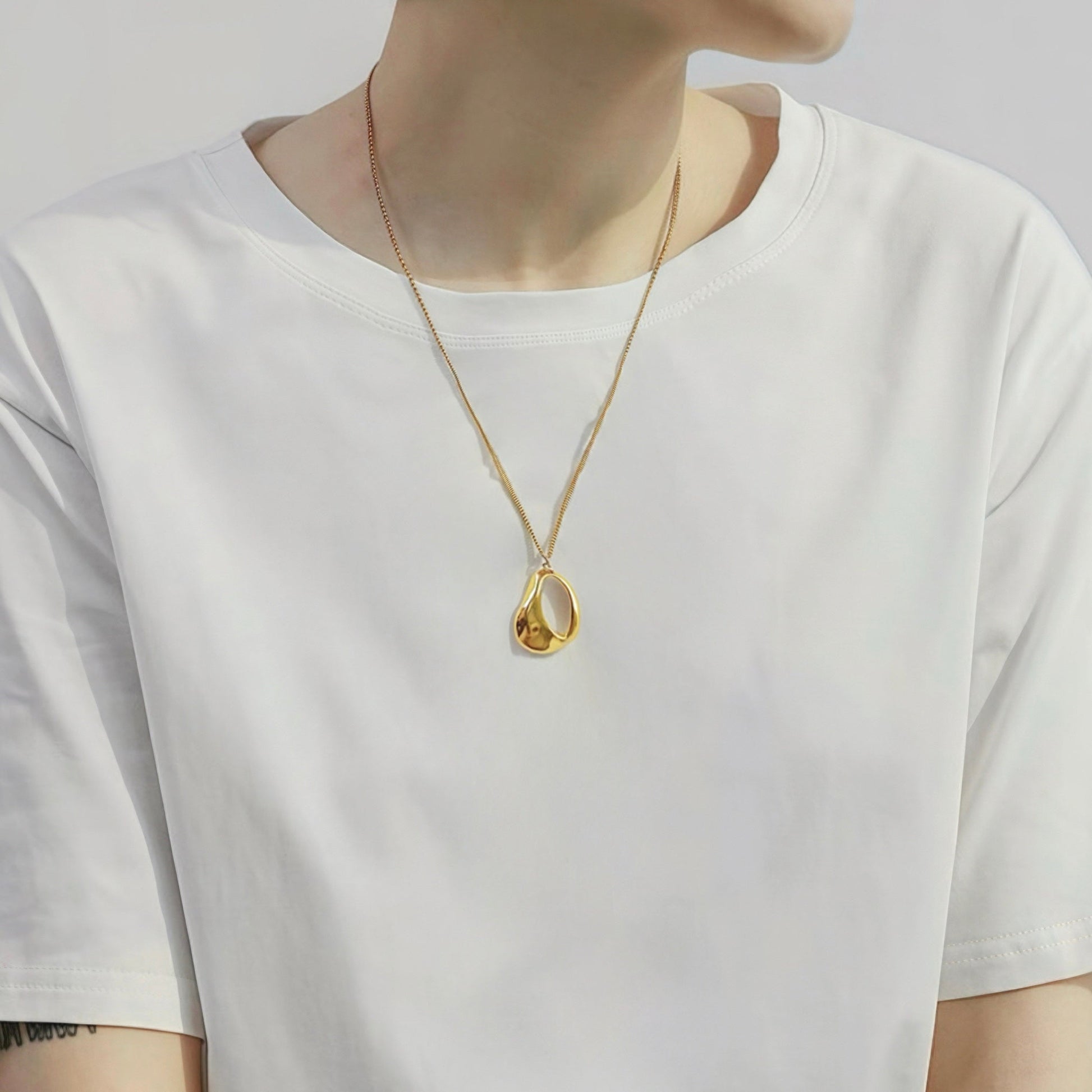 Model styling a Fluid Shapede Pendant Necklace in Gold, ideal for date nights.