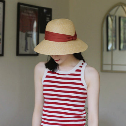 Model wearing red Ribbon Straw Hat. Bold vibrant shade featuring a secure and stylish ribbon chin tie.