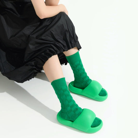 Model wearing a pair of green fuzzy plaid socks, ideal for everyday outfits and sneakers.