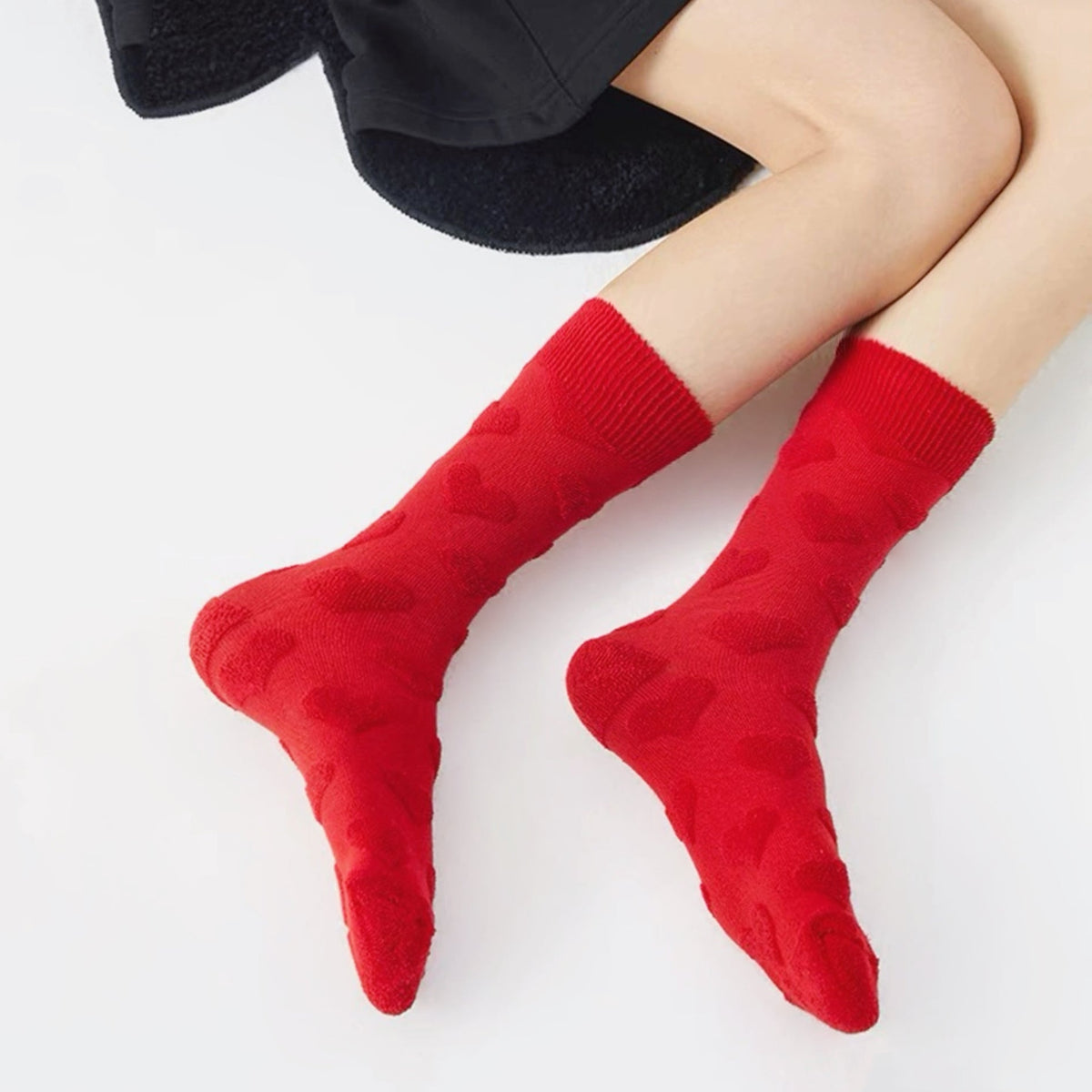 Model wearing a pair of  Fuzzy Embossed Socks in red, great for daily wear and lounging.