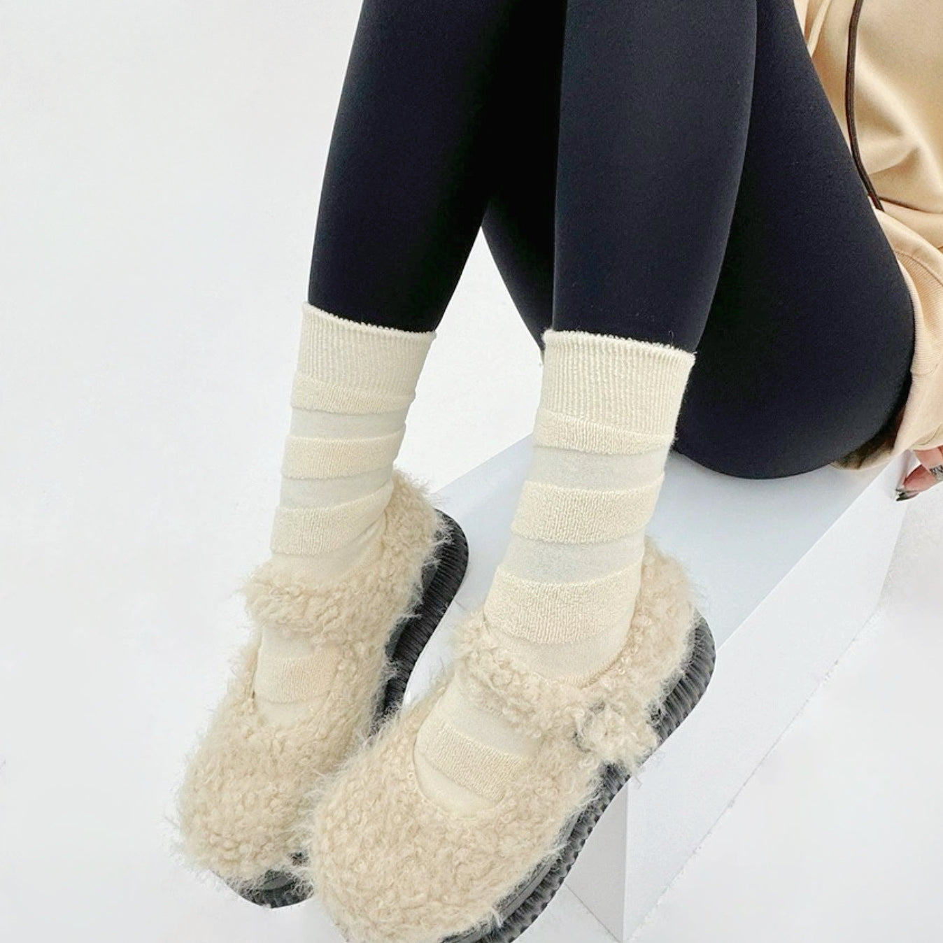 Model wearing a pair of  Fuzzy Embossed Socks in white, ideal for workouts and commuting.