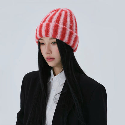 Side profile of the model wearing the red and pink striped knit beanie.