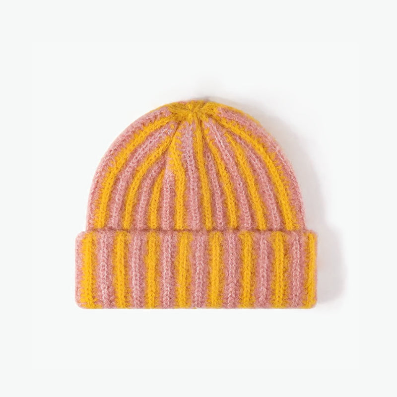 Yellow and coral striped fuzzy beanie displayed flat on a white background.