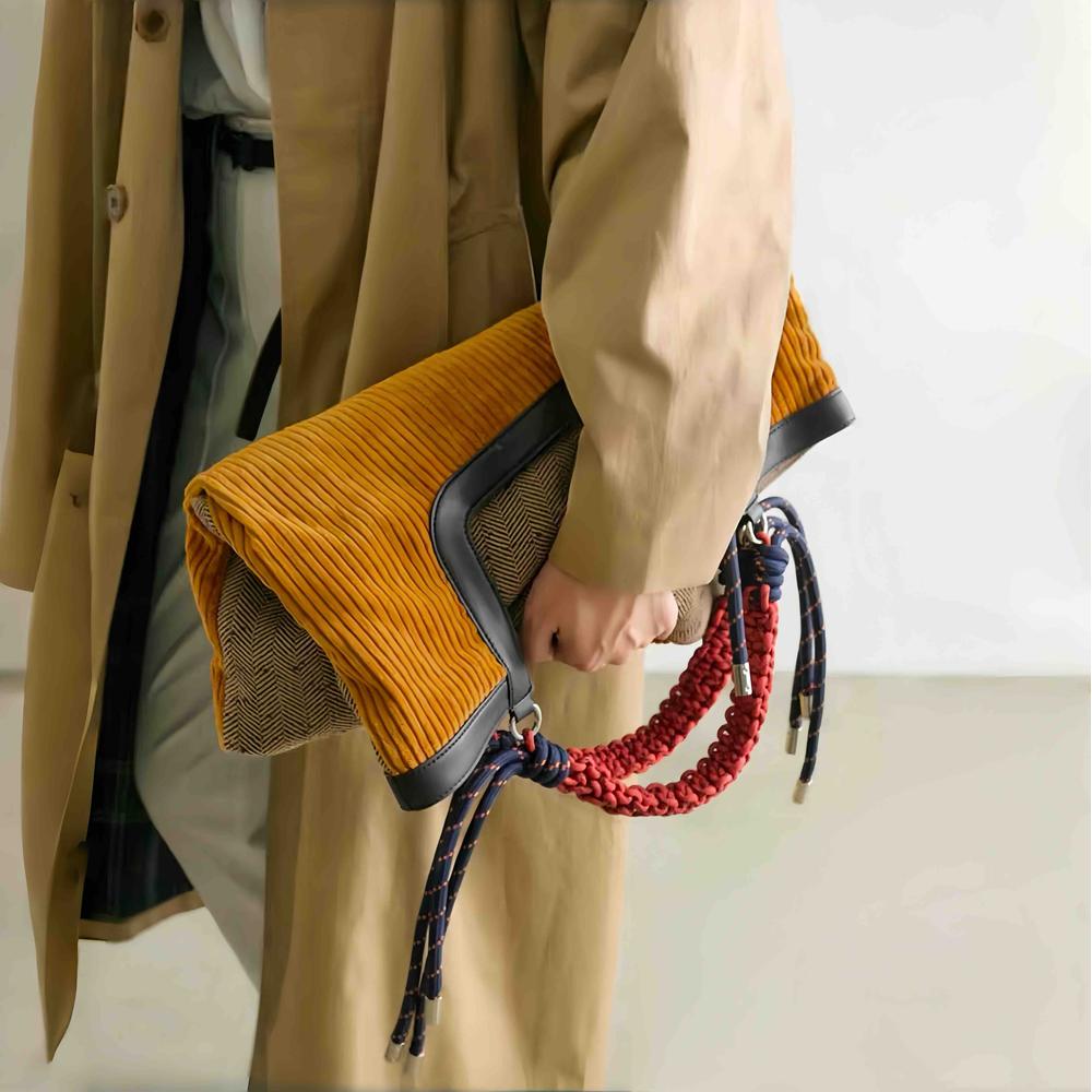 Gentle Beam tote folded into a stylish clutch bag, highlighting the textured tweed back and versatile multi-functional design.