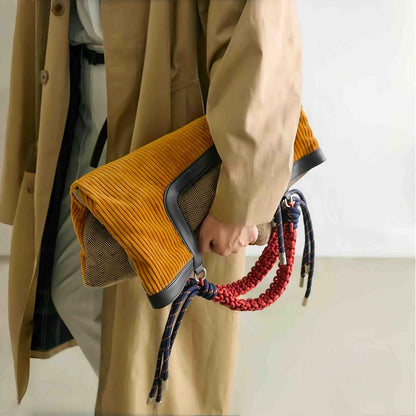 Gentle Beam tote folded into a stylish clutch bag, highlighting the textured tweed back and versatile multi-functional design.