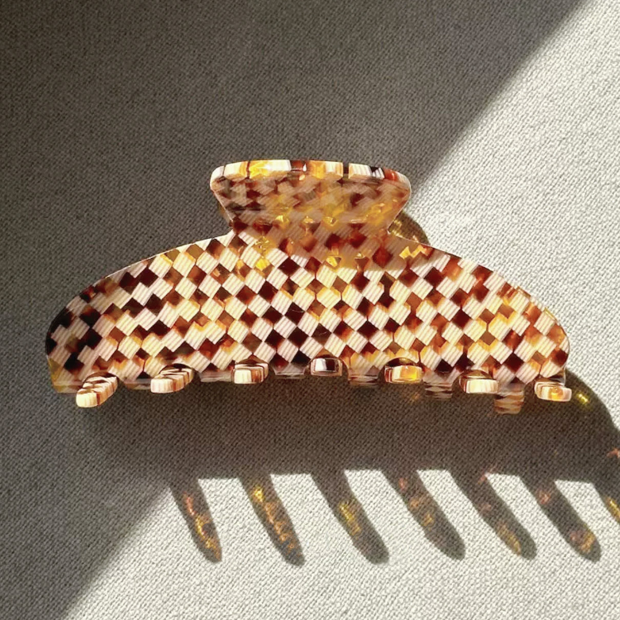 Flat lay of Gentle Curve Claw hair claw clip in brown plaid pattern, easy for workdays and special occasions.