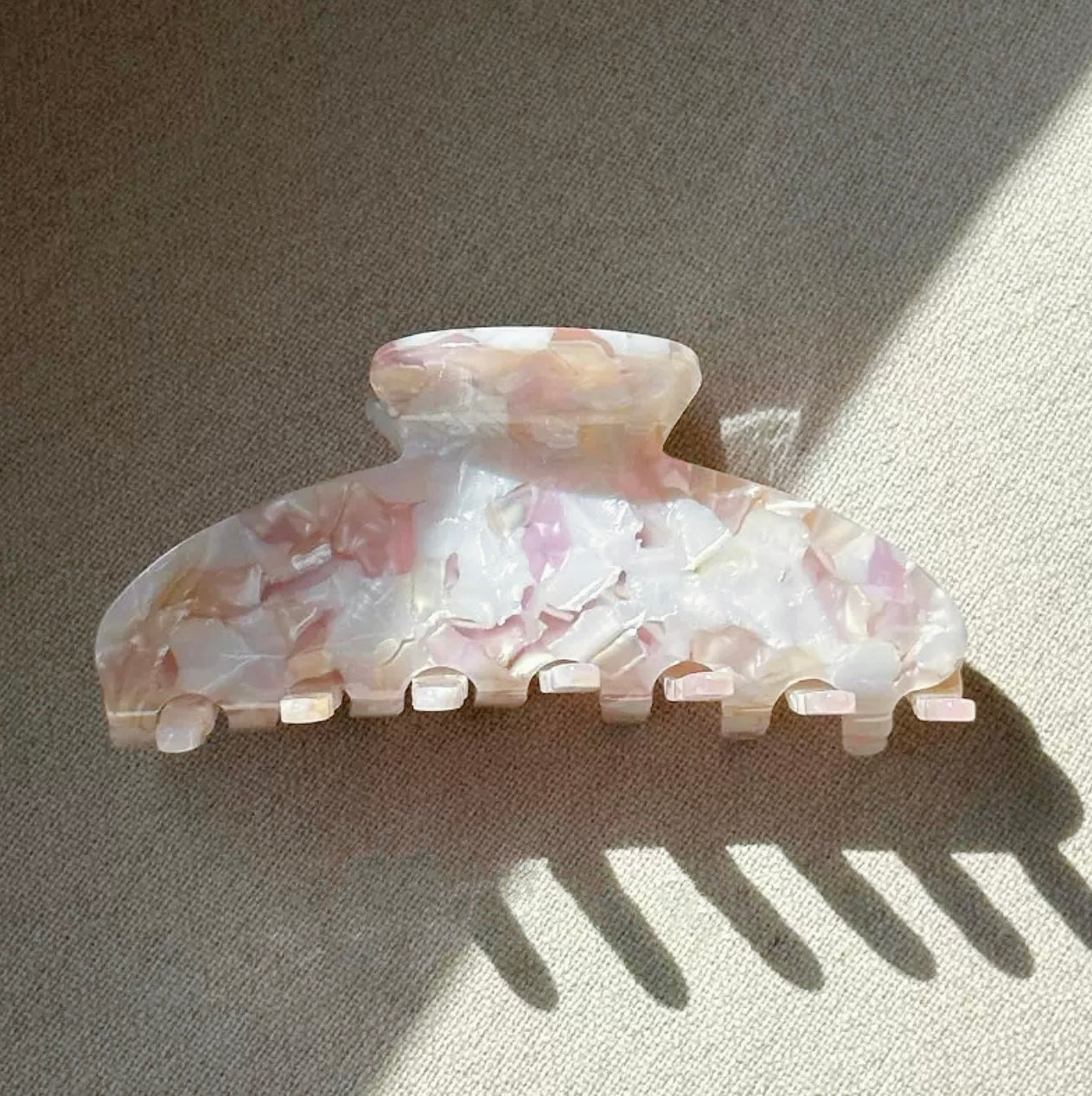 Folded view of Gentle Curve hair claw in rose shell , ideal for quick updos and ponytails.