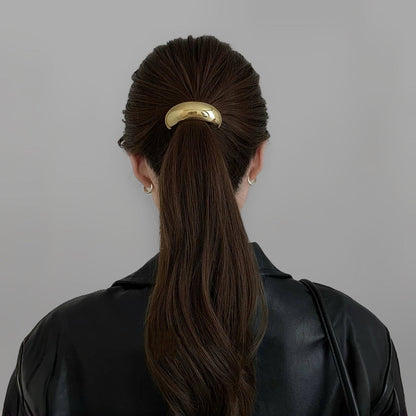 Model wearing a large Gleaming Curve Hair Cuff in gold, easy for workdays and special occasions.