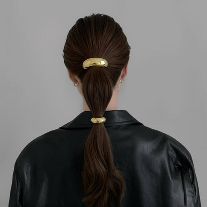 Model wearing two gold  Gleaming Curve Hair Cuffs , great for everyday styling and gifting.