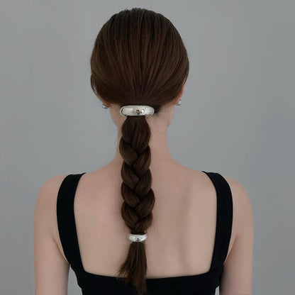 Model wearing two silver Gleaming Curve Hair Cuffs, ideal for quick updos and ponytails.