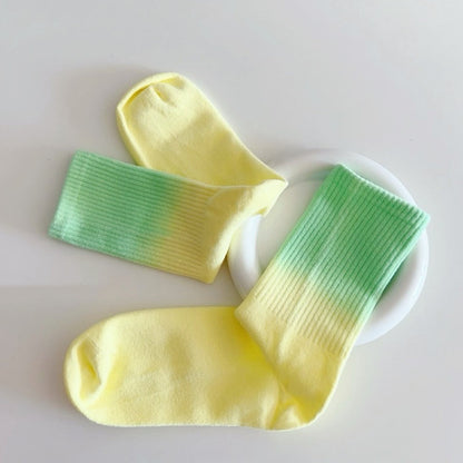 Folded view of Gradient Rainbow Socks in green and yellow, ideal for workouts and commuting.