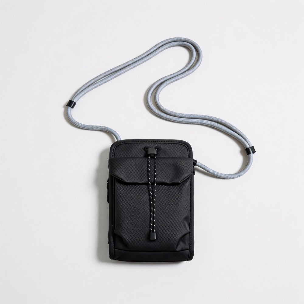 Front flat lay view of the classic black grid magnetic utility crossbody bag with adjustable rope strap.