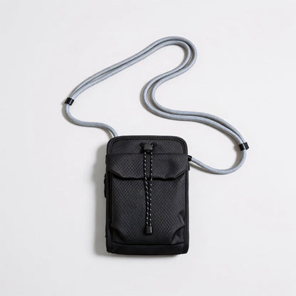 Front flat lay view of the classic black grid magnetic utility crossbody bag with adjustable rope strap.