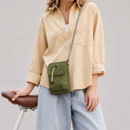 Model wearing the green grid magnetic utility bag as a crossbody pouch.