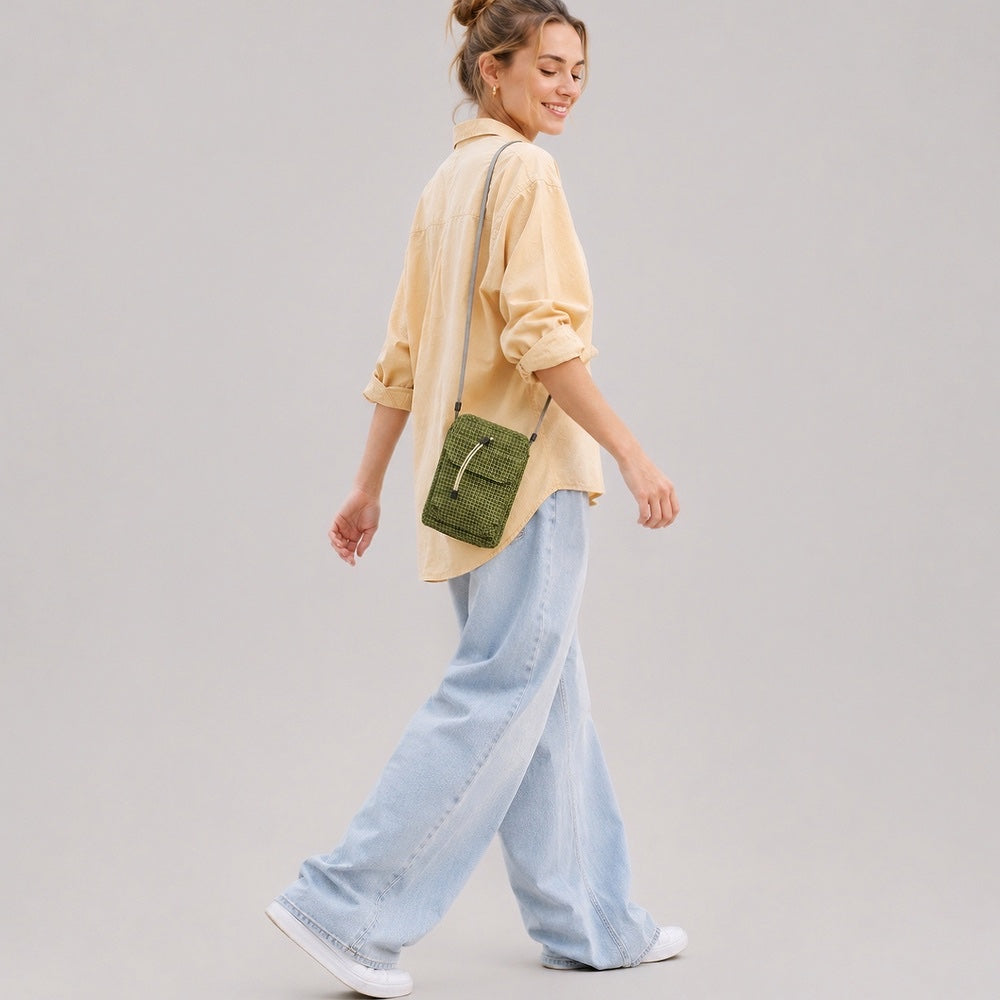 Side view of a model carrying the lightweight green ripstop utility crossbody bag on her shoulder.