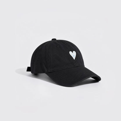 Side angle view of a classic black cotton twill cap featuring white heart embroidery.